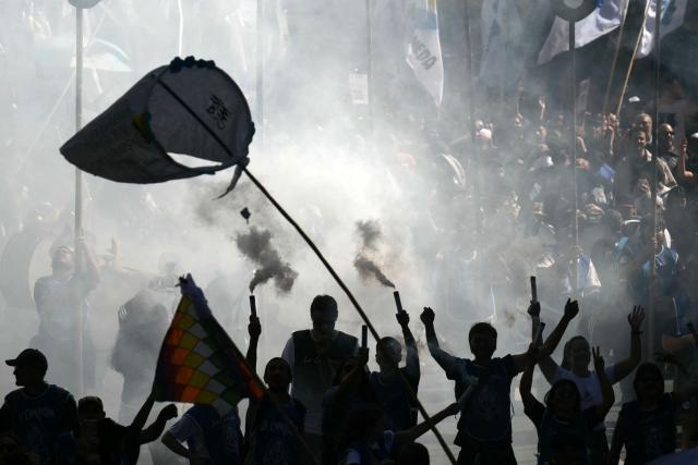 People take part in a march to Plaza de Mayo aquare in Buenos Aires on March 24, 2026, on the 50th anniversary of the beginning of the last military dictatorship. In Argentina, March 24th is a day of mourning, marches and political disputes. Fifty years on from the coup d’etat, thousands of people are taking to the streets again to commemorate the victims of a dictatorship that the government of far-right leader Javier Milei is seeking to rewrite. (Photo by Luis ROBAYO / AFP)