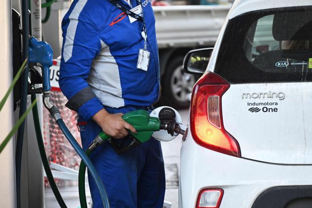 A worker fuels a vehicle at a gas station in Santiago on March 24, 2026. Chile's new government announced on March 23 a historic increase of nearly half a dollar per liter in fuel prices, after carrying out a major adjustment to a state mechanism designed to cushion volatility in international prices. (Photo by Rodrigo ARANGUA / AFP)