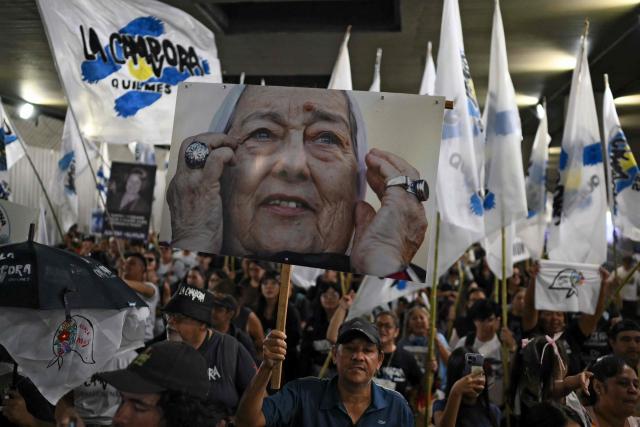 Demonstrators with a sign depicting Hebe de Bonafini -one of the founders of the Human Rights association Madres de Plaza de Mayo - take part in a march to Plaza de Mayo aquare in Buenos Aires on March 24, 2026, on the 50th anniversary of the beginning of the last military dictatorship. In Argentina, March 24th is a day of mourning, marches and political disputes. Fifty years on from the coup detat, thousands of people are taking to the streets again to commemorate the victims of a dictatorship that the government of far-right leader Javier Milei is seeking to rewrite. (Photo by Luis ROBAYO / AFP)