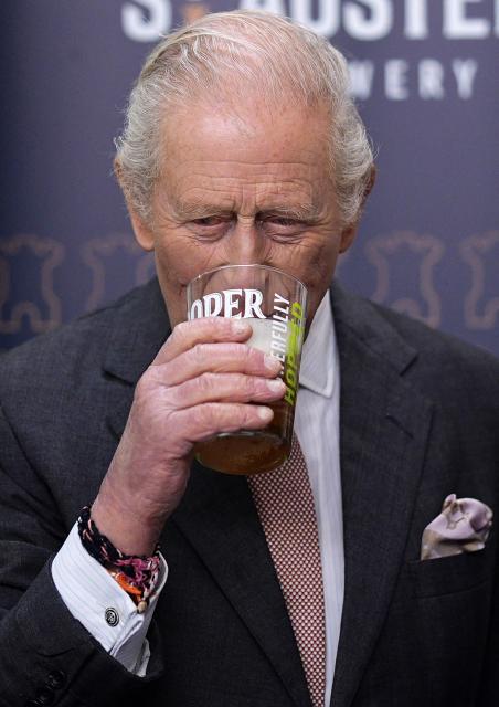 Britain's King Charles III tastes a pint of St Austell Brewery's Proper Job IPA 0.5%, after pulling it, during a visit to the The Market Hall in St Austell, south-west England on March 24, 2026. (Photo by Aaron Chown / POOL / AFP)