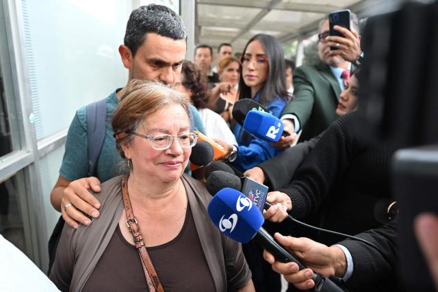 Marina, mother of Colombian soldier German Suarez - who survived a crash of the Air Force Hercules during takeoff in Puerto Leguizamo, near the southern border with Ecuador on March 23, 2026 - is surrounded by the press as she enters the Military Hospital in Bogota, on March 24, 2026. Colombia's military said on March 23 that about 80 troops were believed to be dead after a transport plane crash in the south of the country. (Photo by Daniel MUNOZ / AFP)