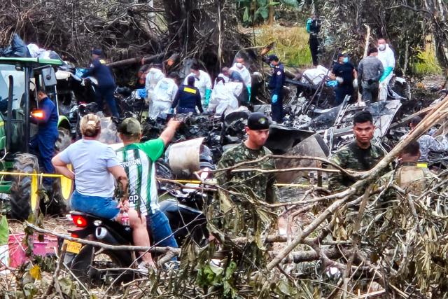Members of the Colombian Attorney General's Office work among debris of the Air Force Hercules that crashed during takeoff in Puerto Leguizamo, Colombia, near the southern border with Ecuador, on March 24, 2026. A Colombian military plane carrying 125 soldiers and crew members crashed on takeoff early on March 23, killing at least 66 people and injuring dozens more, officials said. (Photo by daniel ortiz / AFP)