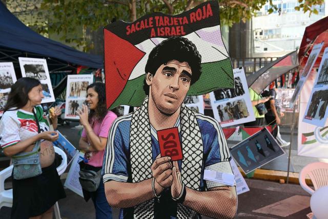 A cutout depicting Argentine football legend Diego Maradona holding a red card and a sign reading “Give Israel a red card” is displayed during a demonstration in front of the Israeli Embassy in Buenos Aires on March 24, 2026, as part of the mobilization marking the 50th anniversary of the military coup. In Argentina, March 24th is a day of mourning, marches and political disputes. Fifty years on from the coup d’etat, thousands of people are taking to the streets again to commemorate the victims of a dictatorship that the government of far-right leader Javier Milei is seeking to rewrite. (Photo by Juan Mabromata / AFP)