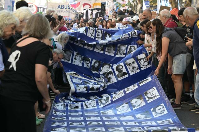 People display a large banner with portraits of people who disappeared during the military dictatorship (1976-1983) while heading to Plaza de Mayo Square to commemorate the 50th anniversary of the military coup in Buenos Aires on
March 24, 2026.. In Argentina, March 24th is a day of mourning, marches and political disputes. Fifty years on from the coup detat, thousands of people are taking to the streets again to commemorate the victims of a dictatorship that the government of far-right leader Javier Milei is seeking to rewrite. (Photo by Juan Mabromata / AFP)
