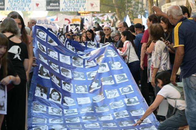 People display a large banner with portraits of people who disappeared during the military dictatorship (1976-1983) while heading to Plaza de Mayo Square to commemorate the 50th anniversary of the military coup in Buenos Aires on
March 24, 2026.. In Argentina, March 24th is a day of mourning, marches and political disputes. Fifty years on from the coup detat, thousands of people are taking to the streets again to commemorate the victims of a dictatorship that the government of far-right leader Javier Milei is seeking to rewrite. (Photo by Juan Mabromata / AFP)
