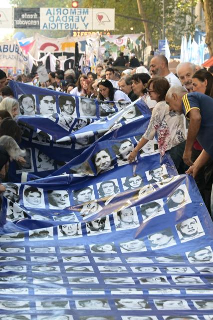 People display a large banner with portraits of people who disappeared during the military dictatorship (1976-1983) while heading to Plaza de Mayo Square to commemorate the 50th anniversary of the military coup in Buenos Aires on
March 24, 2026.. In Argentina, March 24th is a day of mourning, marches and political disputes. Fifty years on from the coup detat, thousands of people are taking to the streets again to commemorate the victims of a dictatorship that the government of far-right leader Javier Milei is seeking to rewrite. (Photo by Juan Mabromata / AFP)