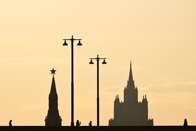 People walk on the Moskvoretsky bridge in view of the Vodovzvodnaya Kremlin tower and Ministry of foreign affairs building in the background, in central Moscow on March 24, 2026. (Photo by Igor IVANKO / AFP)