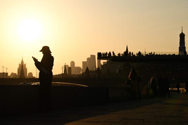 A woman stands on Kremlevskaya embankment with the Moscow panorama in the background, in central Moscow on March 24, 2026. (Photo by Igor IVANKO / AFP)