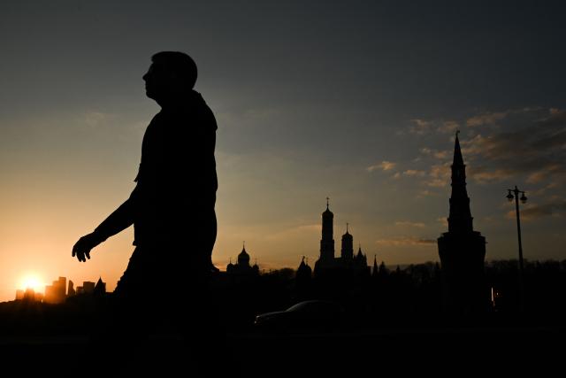 A man walks on Moskvoretsky bridge with a view of the Kremlin in the background, in central Moscow on March 24, 2026. (Photo by Igor IVANKO / AFP)