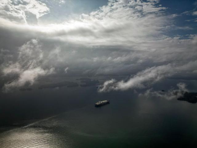 (FILES) This aerial view shows a ship crossing Gatun Lake on its way through the Panama Canal, near Colon, on May 14, 2025. The Panama Canal authority expects to begin, in mid 2027, the first resettlements of populations that will be affected by the construction of a new reservoir along the interoceanic route, a source from the waterway told AFP on March 24, 2026. (Photo by MARTIN BERNETTI / AFP)