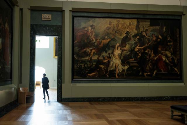 Director of the Paintings Department of Musee du Louvre Sebastien Allard walks next to "L'Apotheose de Henri IV et la proclamation de la regence de la reine" (1622-1625) as he leaves The Medicis Gallery, in which are displayed 24 paintings by Flemish artist Peter Paul Rubens constituting the 'Marie de Medici Cycle', before their restoration, at Musee du Louvre in Paris on March 24, 2026. The Louvre has unveiled the details of an “exceptional operation” to restore the 24 paintings of the “Marie de’ Medici Cycle,” painted in the early 17th century by Rubens, one of the masters of Flemish painting. A call for tenders is underway to find two teams of restorers who will work simultaneously, starting in the autumn, on a project expected to last four years. (Photo by Blanca CRUZ / AFP)