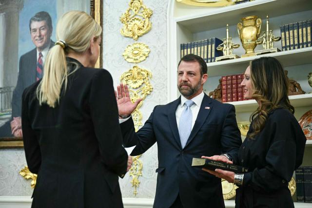 US Attorney General Pam Bondi swears in the new Secretary of Homeland Security Markwayne Mullin, alongside Mullin's wife Christine Mullin, during a ceremony hosted by US President Donald Trump the Oval Office of the White House in Washington, DC, on March 24, 2026. The US Senate on Monday confirmed Mullin as the new chief of the Department of Homeland Security (DHS), the agency reeling from a partial government shutdown as it works to enforce President Donald Trump's immigration crackdown. (Photo by Jim WATSON / AFP)