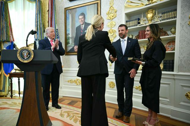 US President Donald Trump (L) applauds after Attorney General Pam Bondi (2L) swore in the new Secretary of Homeland Security Markwayne Mullin (2R), alongside Mullin's wife Christine Mullin (R), in the Oval Office of the White House in Washington, DC, on March 24, 2026. The US Senate on Monday confirmed Mullin as the new chief of the Department of Homeland Security (DHS), the agency reeling from a partial government shutdown as it works to enforce President Donald Trump's immigration crackdown. (Photo by Jim WATSON / AFP)