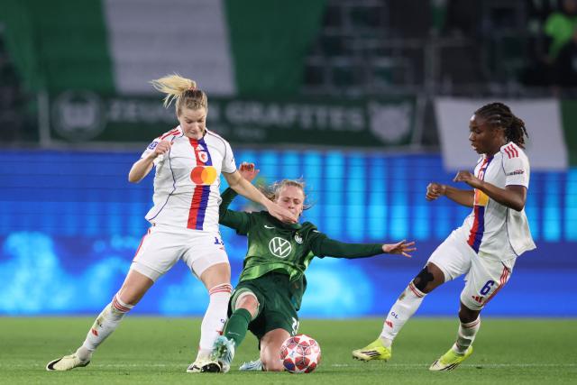 VfL Wolfsburg's German forward #25 Vivien Endemann vies for the ball with Lyon's Norwegian forward #14 Ada Hegerberg and Lyon's Haitian midfielder #06 Melchie Dumornay during the UEFA Women's Champions League Quarter final First Leg football match VfL Wolfsburg v Olympique Lyonnais (OL) in Wolfsburg, northern Germany, on March 24, 2026. (Photo by Ronny HARTMANN / AFP)