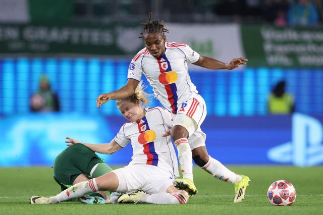 VfL Wolfsburg's German forward #25 Vivien Endemann vies for the ball with Lyon's Norwegian forward #14 Ada Hegerberg and Lyon's Haitian midfielder #06 Melchie Dumornay during the UEFA Women's Champions League Quarter final First Leg football match VfL Wolfsburg v Olympique Lyonnais (OL) in Wolfsburg, northern Germany, on March 24, 2026. (Photo by Ronny HARTMANN / AFP)
