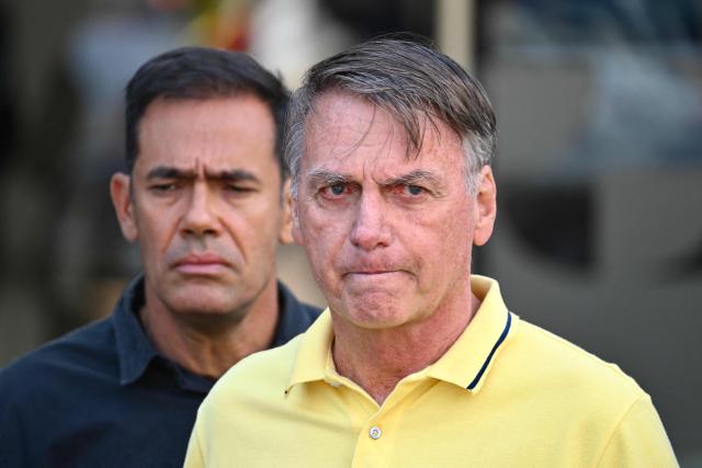 (FILES) Former Brazilian President Jair Bolsonaro gestures after taking medical tests at DF Star hospital in Brasilia on August 16, 2025. A Brazilian Supreme Court judge authorized on March 24, 2026, former President Jair Bolsonaro to serve his sentence under “humanitarian” house arrest as soon as he is discharged from the hospital, where he has been admitted for 11 days for pneumonia. (Photo by Evaristo SA / AFP)