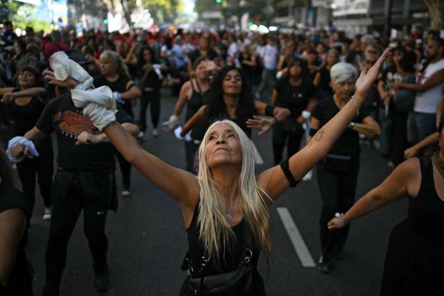 Women dressed in black dance during a march to Mayo Square on the 50th anniversary of the beginning of the last military dictatorship (1976-1983) in Buenos Aires on March 24, 2026. In Argentina, March 24th is a day of mourning, marches and political disputes. Fifty years on from the coup d’etat, thousands of people are taking to the streets again to commemorate the victims of a dictatorship that the government of far-right leader Javier Milei is seeking to rewrite. (Photo by Luis ROBAYO / AFP)