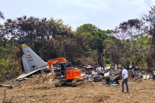 An excavator works at the crash site of the Air Force Hercules aircraft that crashed during takeoff in Puerto Leguizamo, Colombia, near the southern border with Ecuador, on March 24, 2026. The death toll in one of Colombia's worst air accidents in recent history rose to at least 68, an updated tally released on March 24 showed, as the government faulted a "junk" aircraft donated by the United States. (Photo by daniel ortiz / AFP)
