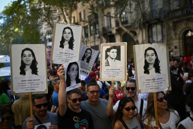 Demonstrators hold portraits of disappeared people during a march to Mayo Square on the 50th anniversary of the beginning of the last military dictatorship (1976-1983) in Buenos Aires on March 24, 2026. In Argentina, March 24th is a day of mourning, marches and political disputes. Fifty years on from the coup d’etat, thousands of people are taking to the streets again to commemorate the victims of a dictatorship that the government of far-right leader Javier Milei is seeking to rewrite. (Photo by Luis ROBAYO / AFP)