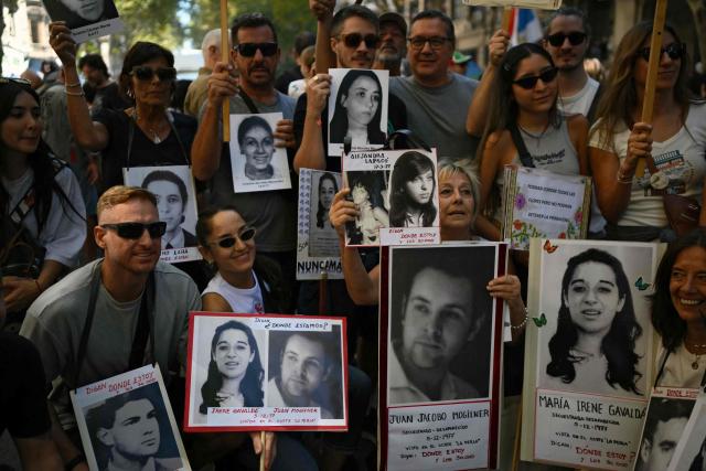 Demonstrators hold portraits of disappeared people during a march to Mayo Square on the 50th anniversary of the beginning of the last military dictatorship (1976-1983) in Buenos Aires on March 24, 2026. In Argentina, March 24th is a day of mourning, marches and political disputes. Fifty years on from the coup d’etat, thousands of people are taking to the streets again to commemorate the victims of a dictatorship that the government of far-right leader Javier Milei is seeking to rewrite. (Photo by Luis ROBAYO / AFP)