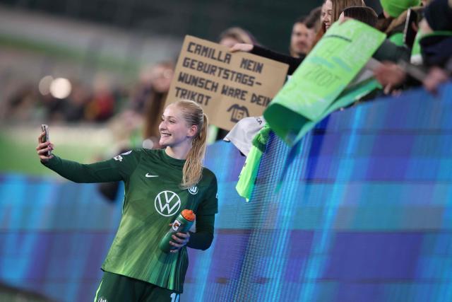 VfL Wolfsburg's German defender #16 Camilla Kuver takes a selfie with fans after the UEFA Women's Champions League Quarter final First Leg football match VfL Wolfsburg v Olympique Lyonnais (OL) in Wolfsburg, northern Germany, on March 24, 2026. (Photo by Ronny HARTMANN / AFP)