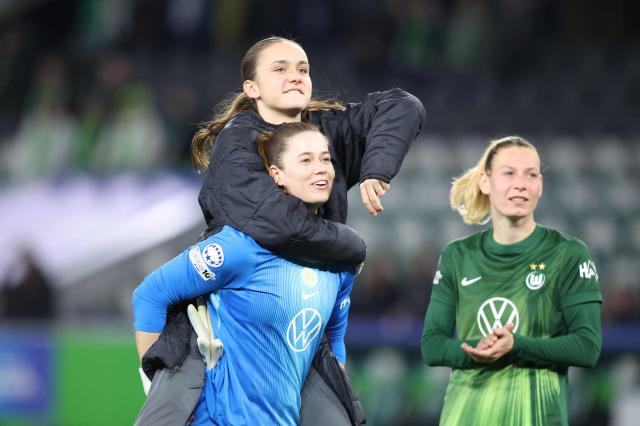 VfL Wolfsburg's German goalkeeper #01 Stina Johannes celebrates with team mates after the UEFA Women's Champions League Quarter final First Leg football match VfL Wolfsburg v Olympique Lyonnais (OL) in Wolfsburg, northern Germany, on March 24, 2026. (Photo by Ronny HARTMANN / AFP)