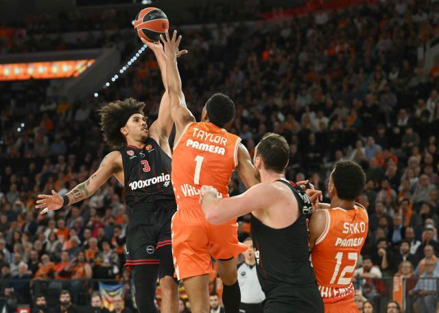 Olympiacos Piraeus' US forward #03 Tyson Ward (L) attempts a shot during the Euroleague basketball match between Valencia Basket and Olympiacos at the Roig arena in Valencia on March 24, 2026. (Photo by JOSE JORDAN / AFP)