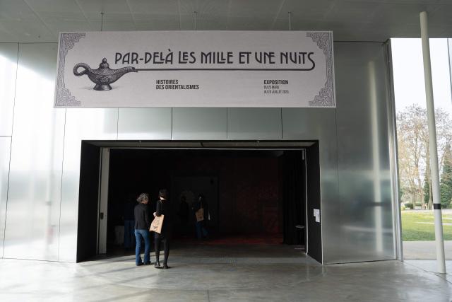 This photograph shows the entrance to the exhibition “Par-dela les Mille et une nuits” (Beyond the Arabian Nights : Histories of Orientalism) at the Louvre-Lens Museum in Lens, northern France, on March 24, 2026. Running from March 25, 2026 to July 20, 2026, the exhibition features a remarkable collection from the Department of Islamic Art at the Louvre Museum with nearly 300 masterpieces seen together for the first time. (Photo by Elise HOUBEN / AFP)