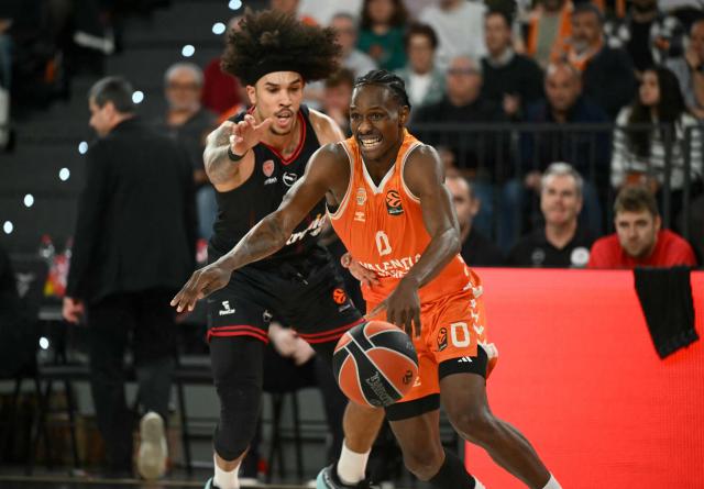 Valencia's Senegalese guard #0 Brancou Badio drives the ball past Olympiacos Piraeus' US forward #03 Tyson Ward during the Euroleague basketball match between Valencia Basket and Olympiacos at the Roig arena in Valencia on March 24, 2026. (Photo by JOSE JORDAN / AFP)