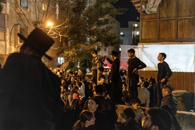 Ultra-Orthodox Jewish men and children look towards the damage at a site struck by a projectile in Bnei Brak, on the eastern outskirts of Tel Aviv, on March 24, 2026. The Middle East was sparked by joint US-Israeli strikes on Iran that triggered a wave of retaliatory missile and drone attacks against Israel and several other countries in the region. (Photo by Ilia YEFIMOVICH / AFP) / 