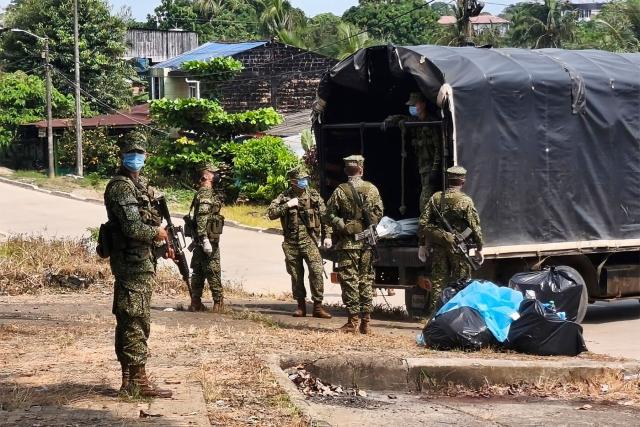 Colombian navy soldiers transport the body of a victim of the Air Force Hercules that crashed during takeoff in Puerto Leguizamo, Colombia, near the southern border with Ecuador on March 24, 2026. At least 69 military personnel and police officers were killed in one of the deadliest plane crashes in Colombia's recent history, according to a new toll released on March 24 for the accident, which the government has attributed to a “junk” aircraft donated by the United States. (Photo by daniel ortiz / AFP)