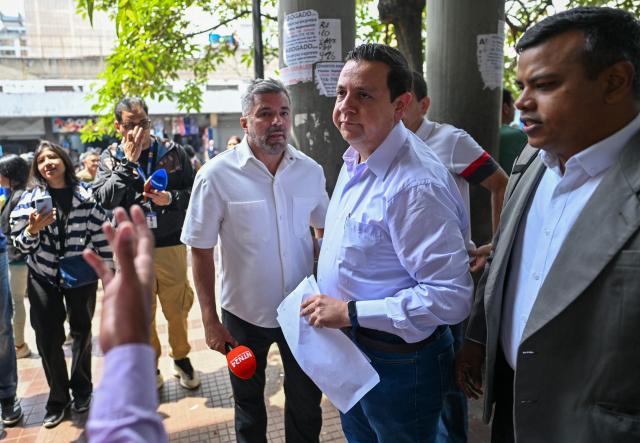 Venezuelan political activist Javier Tarazona (C) gestures outside the Justice Palace in Caracas on March 24, 2026. A Venezuelan court refused to grant an amnesty to renowned activist Javier Tarazona on March 24, 2026, who was released on parole on February 1 after four years incarcerated for "terrorism" and "treason." (Photo by Juan BARRETO / AFP)
