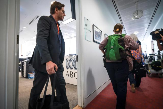 Staff of the ABC, Australia’s national broadcaster, walk out of their office located in the press gallery of Parliament House as they begin a national strike action in Canberra on March 25, 2026. (Photo by DAVID GRAY / AFP)