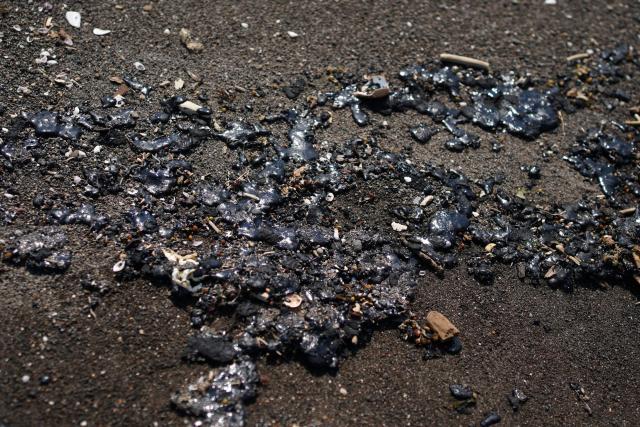 Crude oil slicks are pictured on a beach in Alvarado, Veracruz state, Mexico on March 24, 2026. Mexican authorities and local residents have removed more than 30 tons of "contaminated material" from beaches in the state of Veracruz (in eastern Mexico) following an oil spill reported in early March 2026, the Navy Secretariat announced on March 24. (Photo by Victoria RAZO / AFP)