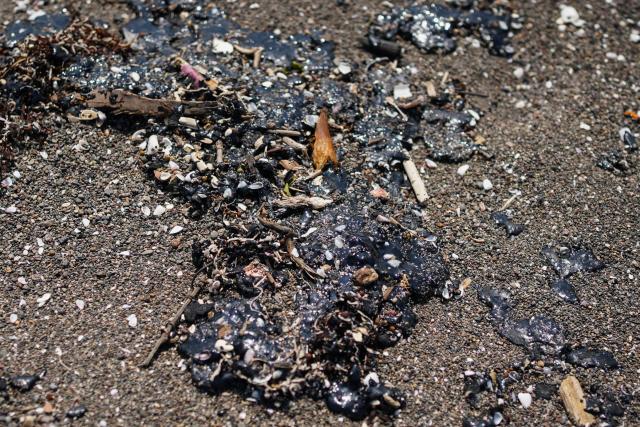 Crude oil slicks are pictured on a beach in Alvarado, Veracruz state, Mexico on March 24, 2026. Mexican authorities and local residents have removed more than 30 tons of "contaminated material" from beaches in the state of Veracruz (in eastern Mexico) following an oil spill reported in early March 2026, the Navy Secretariat announced on March 24. (Photo by Victoria RAZO / AFP)