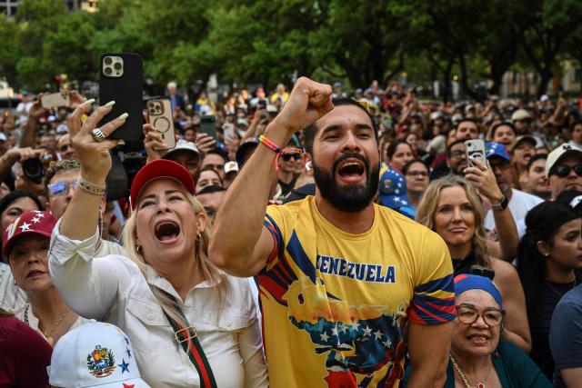 Members of the Venezuelan community cheer as Venezuelan opposition leader Maria Corina Machado speaks in downtown Houston, Texas, on March 24, 2026, after attending the 2026 CERAWeek conference. Machado told AFP on March 24 that her country's formerly all-powerful socialist ideology has been fatally "wounded" by US President Donald Trump. The regime known as "Chavismo" that held Venezuela in its grip for a quarter of a century under Hugo Chavez and his successor Nicolas Maduro is "wounded irreparably and is being dismantled," Machado said. (Photo by RONALDO SCHEMIDT / AFP)
