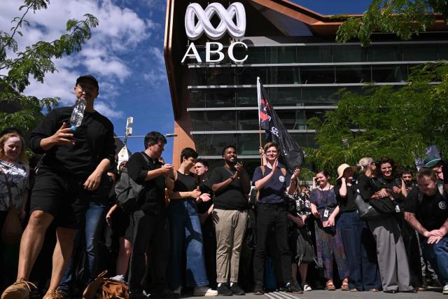 Journalists and staff walk out of the Australian Broadcasting Corporation (ABC) headquarters on strike demanding better pay and protections to stop artificial intelligence taking their jobs, in Melbourne on March 25, 2026. The ABC was forced to replace live programming with pre-recorded shows after more than 2,000 journalists and staff called a 24-hour strike. (Photo by William WEST / AFP)