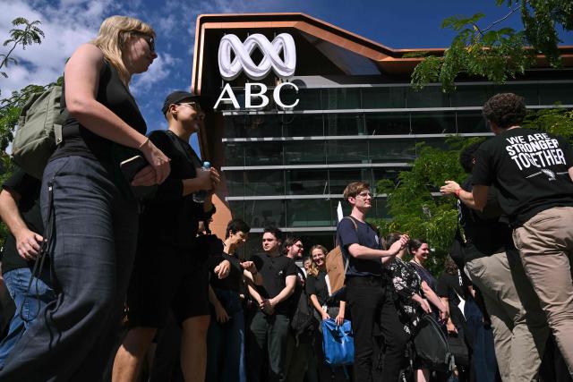Journalists and staff walk out of the Australian Broadcasting Corporation (ABC) headquarters on strike demanding better pay and protections to stop artificial intelligence taking their jobs, in Melbourne on March 25, 2026. The ABC was forced to replace live programming with pre-recorded shows after more than 2,000 journalists and staff called a 24-hour strike. (Photo by William WEST / AFP)