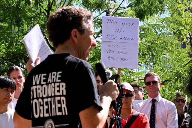 Journalists and staff walk out of the Australian Broadcasting Corporation (ABC) headquarters on strike demanding better pay and protections to stop artificial intelligence taking their jobs, in Melbourne on March 25, 2026. The ABC was forced to replace live programming with pre-recorded shows after more than 2,000 journalists and staff called a 24-hour strike. (Photo by William WEST / AFP)