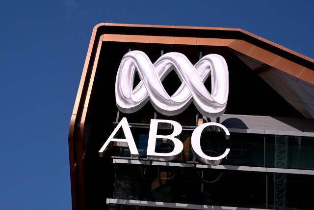 The Australian Broadcasting Corporation (ABC) logo adorns the top of it's Melbourne headquarters, as journalist and staff strike demanding better pay and protections to stop artificial intelligence taking their jobs, in Melbourne on March 25, 2026. The ABC was forced to replace live programming with pre-recorded shows after more than 2,000 journalists and staff called a 24-hour strike. (Photo by William WEST / AFP)