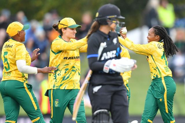 South Africa's Tumi Sekhukhune (R) celebrates with teammates after taking the wicket of New Zealand's Sophie Devine during the fifth Twenty20 international women's cricket match between New Zealand and South Africa at Hagley Oval in Christchurch on March 25, 2026. (Photo by Sanka Vidanagama / AFP)