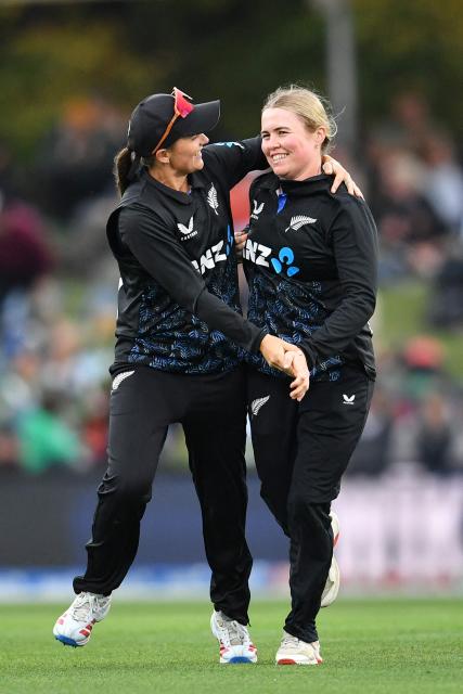 New Zealand's Flora Devonshire (R) celebrates with teammate Amelia Kerr after taking the wicket of South Africa's Kayla Reyneke during the fifth Twenty20 international women's cricket match between New Zealand and South Africa at Hagley Oval in Christchurch on March 25, 2026. (Photo by Sanka Vidanagama / AFP)