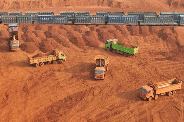 This picture shows a storage yard of imported bauxite from Guinea that was unloaded from ships at Yantai port, in China’s eastern Shandong province on March 25, 2026, where it awaits loading onto trains for delivery to electrolytic aluminum companies. (Photo by CN-STR / AFP) / China OUT