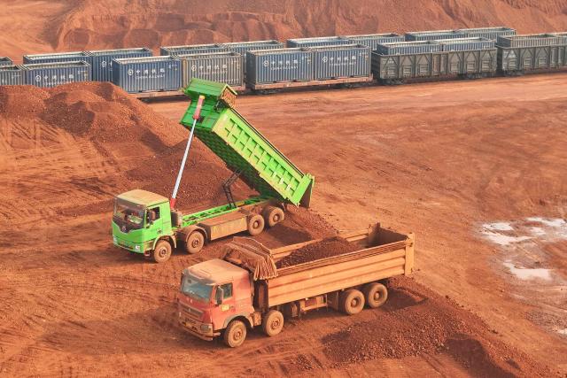 This picture shows a storage yard of imported bauxite from Guinea that was unloaded from ships at Yantai port, in China’s eastern Shandong province on March 25, 2026, where it awaits loading onto trains for delivery to electrolytic aluminum companies. (Photo by CN-STR / AFP) / China OUT