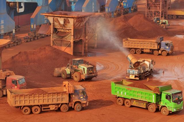 This picture shows a storage yard of imported bauxite from Guinea that was unloaded from ships at Yantai port, in China’s eastern Shandong province on March 25, 2026, where it awaits loading onto trains for delivery to electrolytic aluminum companies. (Photo by CN-STR / AFP) / China OUT