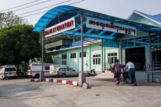 This photo taken on March 17, 2026 shows people outside an emergency department in Naypyidaw that was damaged during a magnitude 7.7 magnitude earthquake on March 28, 2025. The magnitude 7.7 magnitude earthquake on March 28, 2025 killed more than 3,700 people as it razed buildings in Myanmar's central belt, with devastation focused on the second-most-populous city of Mandalay. (Photo by Sai Aung MAIN / AFP)