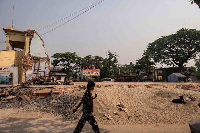 This photo taken on March 19, 2026 shows a girl walking past a cleared site at the Thahtay Kyaung Monastery in Mandalay after a magnitude 7.7 magnitude earthquake on March 28, 2025. The magnitude 7.7 magnitude earthquake on March 28, 2025 killed more than 3,700 people as it razed buildings in Myanmar's central belt, with devastation focused on the second-most-populous city of Mandalay. (Photo by Sai Aung MAIN / AFP)