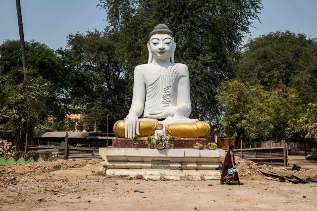 This photo taken on March 19, 2026 shows a Buddhist monk walking past a rebuilt Buddha statue in Mandalay after a magnitude 7.7 magnitude earthquake on March 28, 2025. The magnitude 7.7 magnitude earthquake on March 28, 2025 killed more than 3,700 people as it razed buildings in Myanmar's central belt, with devastation focused on the second-most-populous city of Mandalay. (Photo by Sai Aung MAIN / AFP)