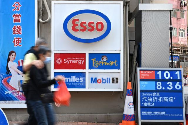 Pedestrians walk past a petrol station in Hong Kong on March 25, 2026. (Photo by Peter PARKS / AFP)