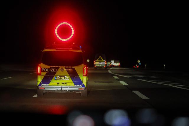 The truck carrying a Castor container for high-level radioactive waste is escorted by police vehicles as it drives on the A3 motorway in Bottrop, western Germany, on March 25, 2026. (Photo by Christoph Reichwein / dpa pool / AFP)